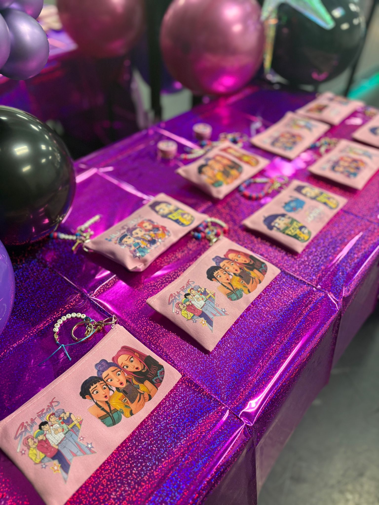 Finished personalized pink pouches displayed alongside event balloons